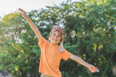 Pilot şapkası takan bir çocuk oyuncak bir uçakla çimlerde koşuyor, maceralar hayal ediyor. Çocukluk, hayal gücü ve özgürlük kavramı..