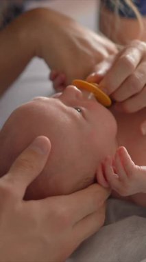 Yeni doğmuş bir bebek ve annesi bir osteopattan sağlık kontrolü ve olası sorunlara karşı nazik bir terapi görürler. Bebek sağlığına, refahına ve erken gelişime odaklanmış bir an.