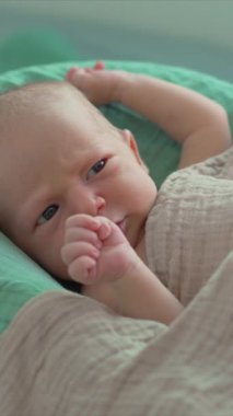 Yeni doğmuş bir bebek, yumuşak çarşafla örtülü, rahat bir bebek kozasında huzur içinde yatar. Huzurlu ve rahat bir an. Bebeklerin ilk günleri için rahatlık ve ilgiyi ön plana çıkarıyor.
