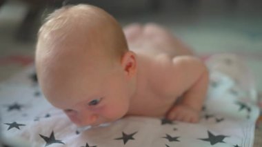 Çıplak yeni doğmuş bir bebek, su geçirmez bir peçetenin üzerine uzanır. Bezsiz geçen zamanın tadını çıkarır, derileri nefes alır. Bebek bakımı gereksinimlerini vurgulayan huzurlu bir an, bebek emziğini desteklemek için ideal ya da