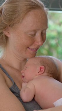 Genç bir anne sevgiyle kucağında küçük bebeğini kucağına alır. Yürek ısıtan bir bağ ve şefkat anını paylaşır. Aşkın güzel bir ifadesi, bağlanma ve anneliğin başlangıcı.