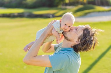 Baba ve yeni doğmuş bebek parkta bir çayırda. Doğada sevgi ve bağlanma anı. Ebeveynlik, babalık ve aile bağları kavramı.