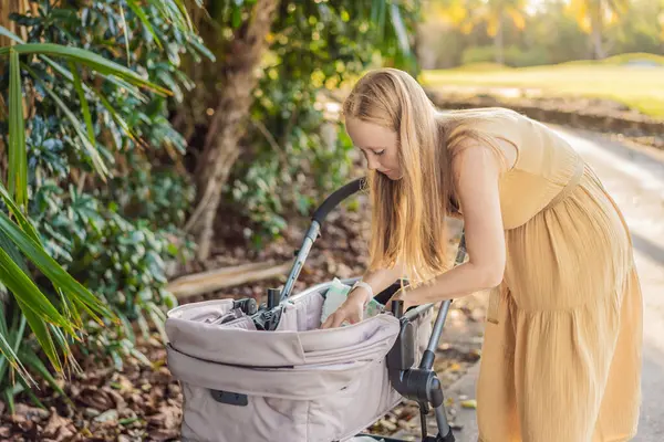 Anne bebek arabasında bebek bezini değiştiriyor. Ebeveynlik, bebek bakımı ve annelik konsepti.