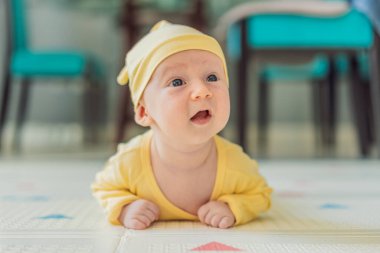 Bir aylık bir bebek karnının üstünde yatıyor ve tuhaf bir şekilde çevreyi gözlemliyor. Boyun dayanıklılığı, bilişsel gelişim ve erken keşif için bebek midesi zamanı. Ebeveynlik ve yeni doğan büyüme kavramı.