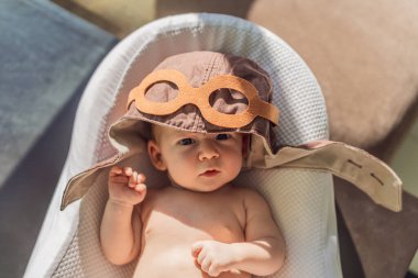 Pilot şapkası takan bebek, havacılık hayallerini simgeliyor. Uçmayı öğrenme kavramı, geleceğin pilotu ve çocukluk arzusu. Havacılık, hayal gücü ve kariyer ilham konsepti.