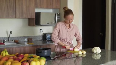 Genç bir kadın mutfakta yemek pişiriyor ve lezzetli bir ev yemeği hazırlamaya odaklanıyor. Sıcacık bir ortamda ev yapımı, yaratıcılık ve aşçılık keyfi.