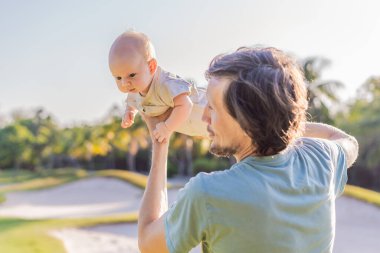 Baba ve yeni doğmuş bebek parkta bir çayırda. Doğada sevgi ve bağlanma anı. Ebeveynlik, babalık ve aile bağları kavramı.