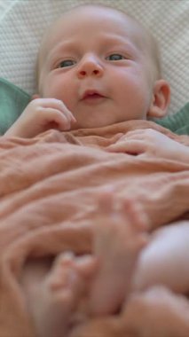 Yeni doğmuş bir bebek, yumuşak çarşafla örtülü, rahat bir bebek kozasında huzur içinde yatar. Huzurlu ve rahat bir an. Bebeklerin ilk günleri için rahatlık ve ilgiyi ön plana çıkarıyor.