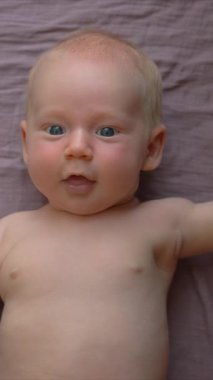 Bir anne yeni doğmuş bebeğiyle nazikçe jimnastik yapar, bebek kollarını ve bacaklarını hafifçe hareket ettirir. Bağ kurmayı, esnekliği ve bebek refahını teşvik eden hassas ve besleyici bir faaliyet.