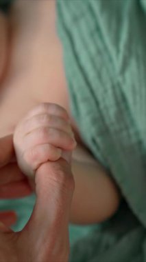 Aktif bir yeni doğan bebek, babasıyla çocuğu arasında hassas bir bağ, sevgi ve erken bir bağ olduğunu gösteren parmağını tutar.