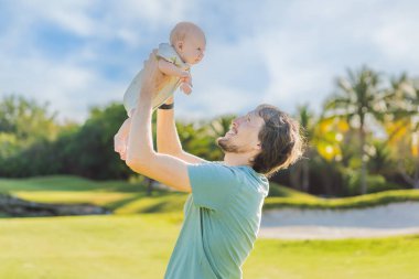 Baba ve yeni doğmuş bebek parkta bir çayırda. Doğada sevgi ve bağlanma anı. Ebeveynlik, babalık ve aile bağları kavramı.