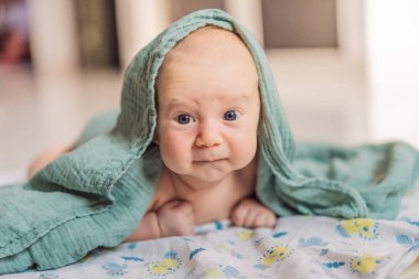 Bir aylık bir bebek karnının üstünde yatıyor ve tuhaf bir şekilde çevreyi gözlemliyor. Boyun dayanıklılığı, bilişsel gelişim ve erken keşif için bebek midesi zamanı. Ebeveynlik ve yeni doğan büyüme kavramı.