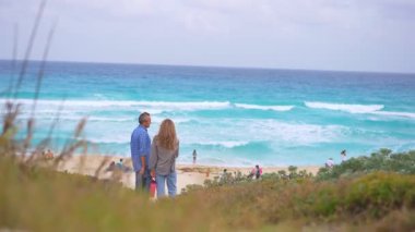 Romantik orta yaşlı çift kumsalda huzurlu bir akşamın tadını çıkarıyor. Olgun ilişkiler ve yavaş yaşam tarzı için aşk, bağlantı ve birliktelik kavramı
