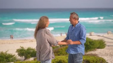 Romantik orta yaşlı çift kumsalda huzurlu bir akşamın tadını çıkarıyor. Olgun ilişkiler ve yavaş yaşam tarzı için aşk, bağlantı ve birliktelik kavramı