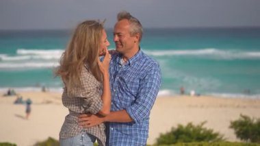 Romantik orta yaşlı çift kumsalda huzurlu bir akşamın tadını çıkarıyor. Olgun ilişkiler ve yavaş yaşam tarzı için aşk, bağlantı ve birliktelik kavramı