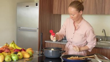 Genç bir kadın mutfakta yemek pişiriyor ve lezzetli bir ev yemeği hazırlamaya odaklanıyor. Sıcacık bir ortamda ev yapımı, yaratıcılık ve aşçılık keyfi.