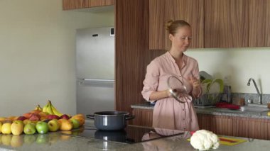 Genç bir kadın mutfakta yemek pişiriyor ve lezzetli bir ev yemeği hazırlamaya odaklanıyor. Sıcacık bir ortamda ev yapımı, yaratıcılık ve aşçılık keyfi.