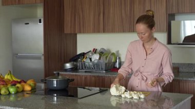 Genç bir kadın mutfakta yemek pişiriyor ve lezzetli bir ev yemeği hazırlamaya odaklanıyor. Sıcacık bir ortamda ev yapımı, yaratıcılık ve aşçılık keyfi.