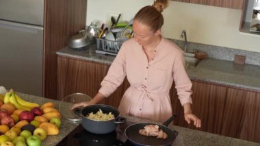 Genç bir kadın mutfakta yemek pişiriyor ve lezzetli bir ev yemeği hazırlamaya odaklanıyor. Sıcacık bir ortamda ev yapımı, yaratıcılık ve aşçılık keyfi.