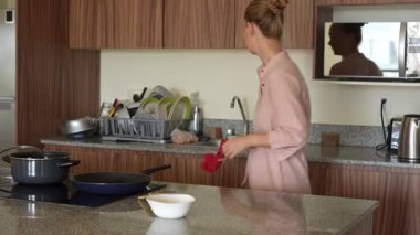 Genç bir kadın mutfakta yemek pişiriyor ve lezzetli bir ev yemeği hazırlamaya odaklanıyor. Sıcacık bir ortamda ev yapımı, yaratıcılık ve aşçılık keyfi.