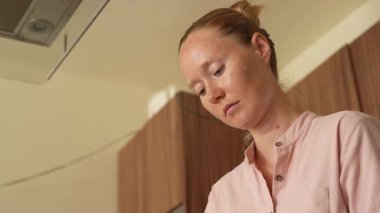 Genç bir kadın mutfakta yemek pişiriyor ve lezzetli bir ev yemeği hazırlamaya odaklanıyor. Sıcacık bir ortamda ev yapımı, yaratıcılık ve aşçılık keyfi.