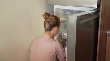 Genç bir kadın mutfakta yemek pişiriyor ve lezzetli bir ev yemeği hazırlamaya odaklanıyor. Sıcacık bir ortamda ev yapımı, yaratıcılık ve aşçılık keyfi.