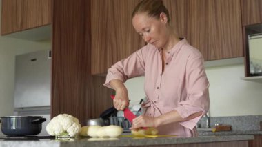 Genç bir kadın mutfakta yemek pişiriyor ve lezzetli bir ev yemeği hazırlamaya odaklanıyor. Sıcacık bir ortamda ev yapımı, yaratıcılık ve aşçılık keyfi.