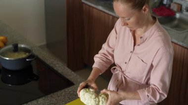 Genç bir kadın mutfakta yemek pişiriyor ve lezzetli bir ev yemeği hazırlamaya odaklanıyor. Sıcacık bir ortamda ev yapımı, yaratıcılık ve aşçılık keyfi.