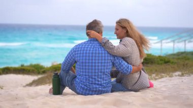 Romantik orta yaşlı çift kumsalda huzurlu bir akşamın tadını çıkarıyor. Olgun ilişkiler ve yavaş yaşam tarzı için aşk, bağlantı ve birliktelik kavramı