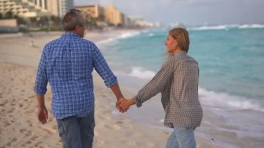 Romantik orta yaşlı çift kumsalda huzurlu bir akşamın tadını çıkarıyor. Olgun ilişkiler ve yavaş yaşam tarzı için aşk, bağlantı ve birliktelik kavramı