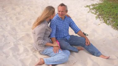 Romantik orta yaşlı çift kumsalda huzurlu bir akşamın tadını çıkarıyor. Olgun ilişkiler ve yavaş yaşam tarzı için aşk, bağlantı ve birliktelik kavramı
