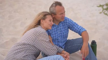 Romantik orta yaşlı çift kumsalda huzurlu bir akşamın tadını çıkarıyor. Olgun ilişkiler ve yavaş yaşam tarzı için aşk, bağlantı ve birliktelik kavramı