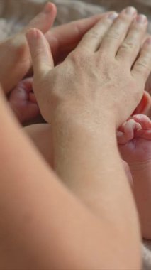 Banyodan sonra anne yeni doğan bebeğine nazikçe masaj yapar ve bebekler için cilt yağı sürer. Bebek konforu, rahatlama ve sağlıklı cilt için hassas bir bağ ve bakım anı.