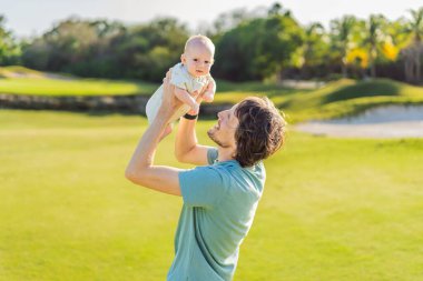 Baba ve yeni doğmuş bebek parkta bir çayırda. Doğada sevgi ve bağlanma anı. Ebeveynlik, babalık ve aile bağları kavramı.
