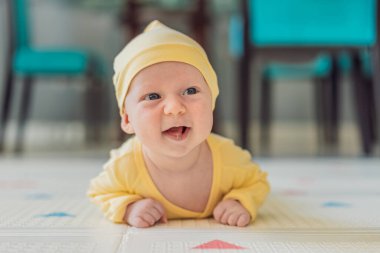 Bir aylık bir bebek karnının üstünde yatıyor ve tuhaf bir şekilde çevreyi gözlemliyor. Boyun dayanıklılığı, bilişsel gelişim ve erken keşif için bebek midesi zamanı. Ebeveynlik ve yeni doğan büyüme kavramı.