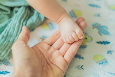 Babalar bebeklerini nazikçe kucağında tutarak sevgi, koruma ve aile bağını sembolize eder. Ebeveynlik, ilgi ve şefkat kavramı.