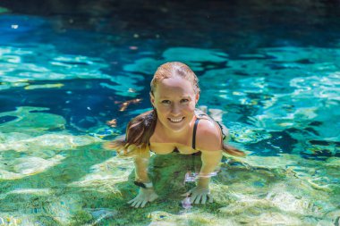 Kadın turist, turkuaz suyla Meksika mezarlığında ferahlatıcı bir yüzüşten zevk alıyor. Macera, seyahat ve doğa keşfi konsepti.