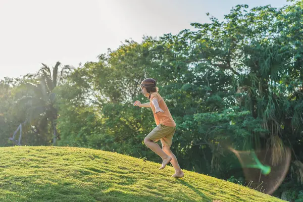 Pilot şapkası takan bir çocuk oyuncak bir uçakla çimlerde koşuyor, maceralar hayal ediyor. Çocukluk, hayal gücü ve özgürlük kavramı..