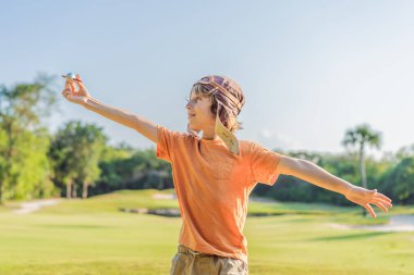 Pilot şapkası takan bir çocuk oyuncak bir uçakla çimlerde koşuyor, maceralar hayal ediyor. Çocukluk, hayal gücü ve özgürlük kavramı..