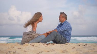 Romantik orta yaşlı çift kumsalda huzurlu bir akşamın tadını çıkarıyor. Olgun ilişkiler ve yavaş yaşam tarzı için aşk, bağlantı ve birliktelik kavramı