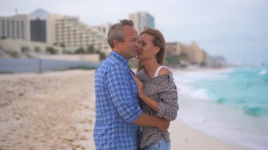 Romantik orta yaşlı çift kumsalda huzurlu bir akşamın tadını çıkarıyor. Olgun ilişkiler ve yavaş yaşam tarzı için aşk, bağlantı ve birliktelik kavramı