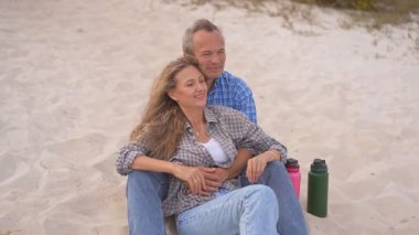Romantik orta yaşlı çift kumsalda huzurlu bir akşamın tadını çıkarıyor. Olgun ilişkiler ve yavaş yaşam tarzı için aşk, bağlantı ve birliktelik kavramı