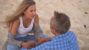 Romantik orta yaşlı çift kumsalda huzurlu bir akşamın tadını çıkarıyor. Olgun ilişkiler ve yavaş yaşam tarzı için aşk, bağlantı ve birliktelik kavramı