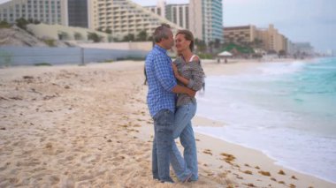 Romantik orta yaşlı çift kumsalda huzurlu bir akşamın tadını çıkarıyor. Olgun ilişkiler ve yavaş yaşam tarzı için aşk, bağlantı ve birliktelik kavramı