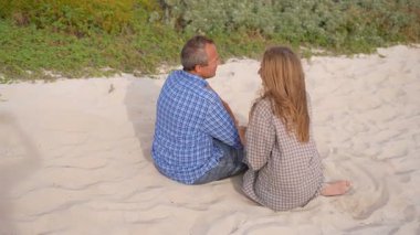 Romantik orta yaşlı çift kumsalda huzurlu bir akşamın tadını çıkarıyor. Olgun ilişkiler ve yavaş yaşam tarzı için aşk, bağlantı ve birliktelik kavramı