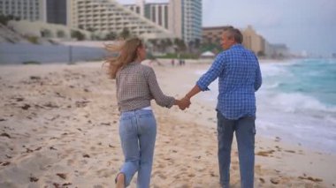 Romantik orta yaşlı çift kumsalda huzurlu bir akşamın tadını çıkarıyor. Olgun ilişkiler ve yavaş yaşam tarzı için aşk, bağlantı ve birliktelik kavramı