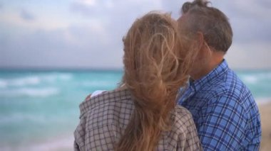 Romantik orta yaşlı çift kumsalda huzurlu bir akşamın tadını çıkarıyor. Olgun ilişkiler ve yavaş yaşam tarzı için aşk, bağlantı ve birliktelik kavramı