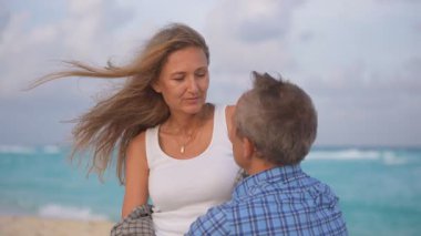 Romantik orta yaşlı çift kumsalda huzurlu bir akşamın tadını çıkarıyor. Olgun ilişkiler ve yavaş yaşam tarzı için aşk, bağlantı ve birliktelik kavramı