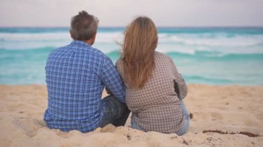 Romantik orta yaşlı çift kumsalda huzurlu bir akşamın tadını çıkarıyor. Olgun ilişkiler ve yavaş yaşam tarzı için aşk, bağlantı ve birliktelik kavramı