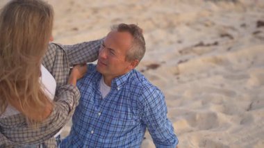 Romantik orta yaşlı çift kumsalda huzurlu bir akşamın tadını çıkarıyor. Olgun ilişkiler ve yavaş yaşam tarzı için aşk, bağlantı ve birliktelik kavramı